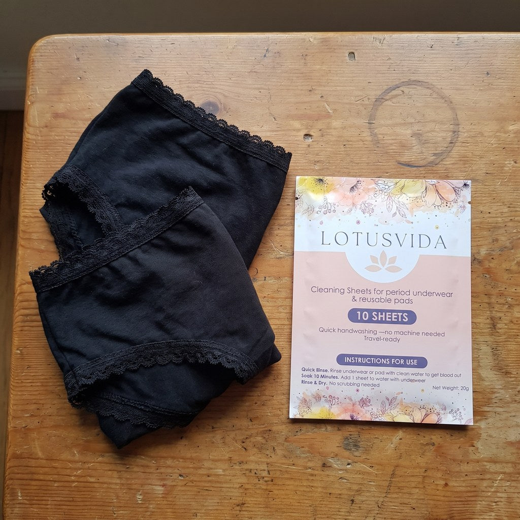 Two pairs of period underwear and the detergent pack on a table