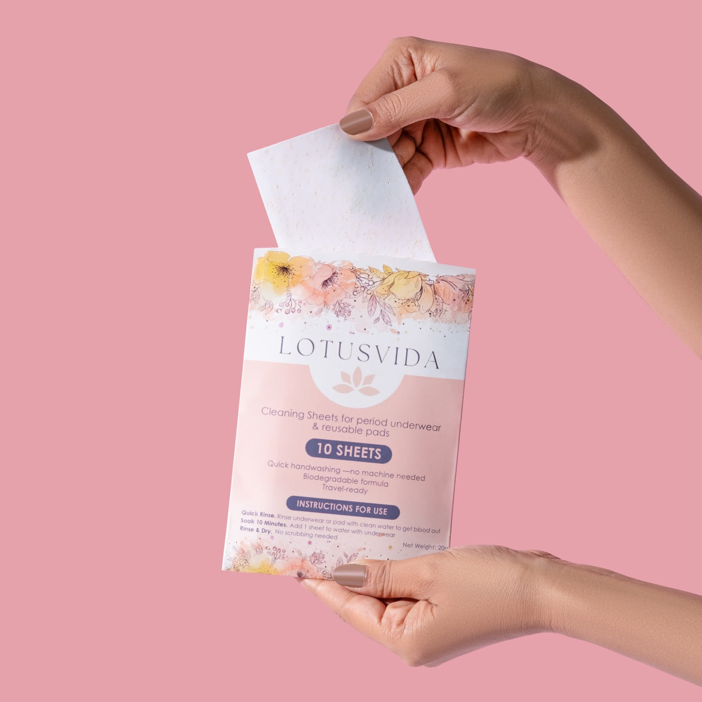 A hand lifting a LotusVida cleaning sheet from the pack
